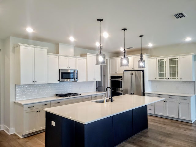123 Leeward Lndg, Summerville, SC 29486 - kitchen featuring stainless steel appliances, a sink, wood finished floors, backsplash, and white cabinetry
