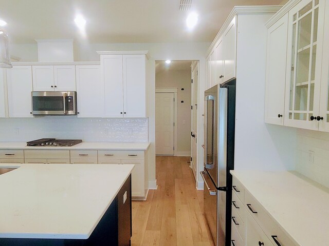 123 Leeward Lndg, Summerville, SC 29486 - kitchen featuring stainless steel appliances, white cabinetry, light wood-type flooring, decorative backsplash, and light countertops
