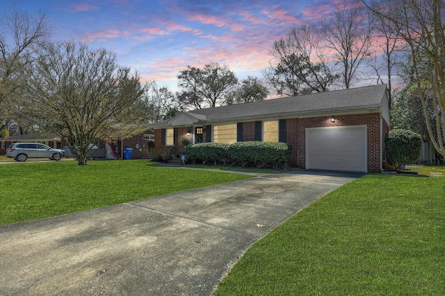 single story home with brick siding, a garage, a lawn, and driveway