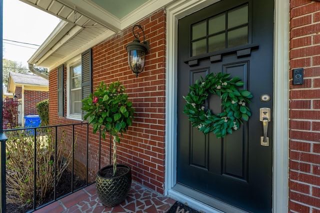 property entrance with covered porch and brick siding