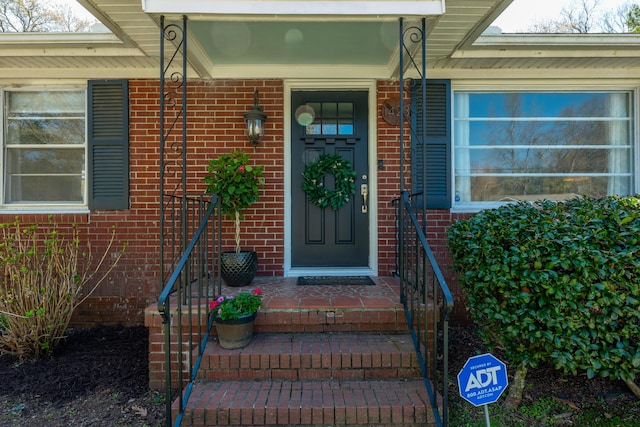 entrance to property featuring brick siding