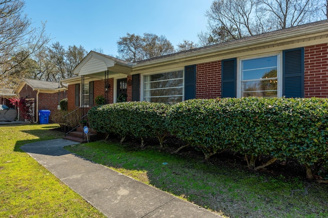 ranch-style house featuring brick siding and a front yard