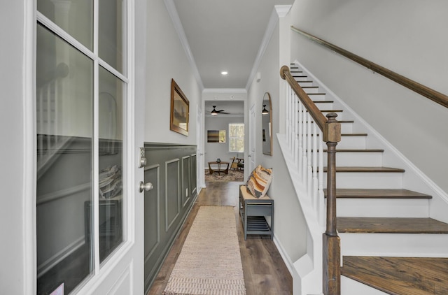 stairs featuring ceiling fan, wood-type flooring, and ornamental molding