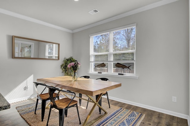 dining space featuring dark hardwood / wood-style flooring and crown molding