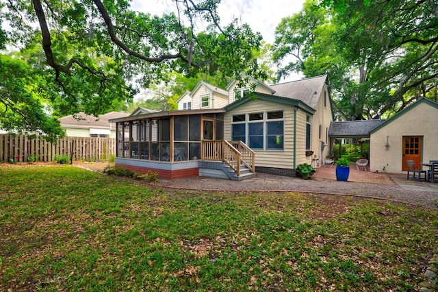 rear view of property with a sunroom and a patio