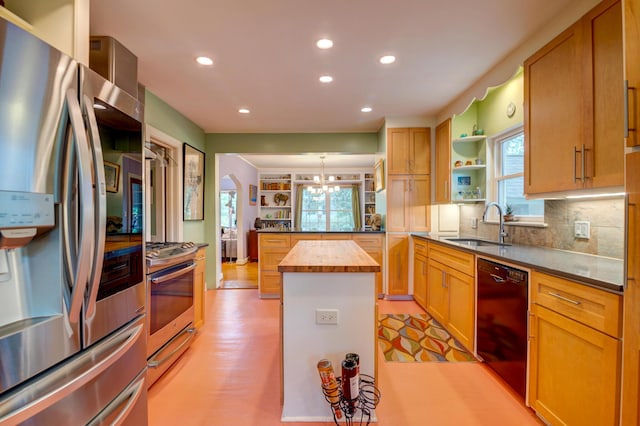 kitchen featuring appliances with stainless steel finishes, a peninsula, butcher block countertops, a sink, and recessed lighting