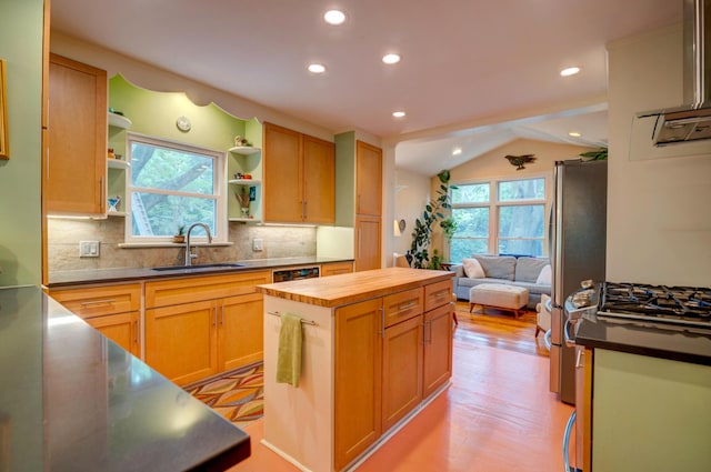 kitchen with a sink, plenty of natural light, butcher block counters, open shelves, and vaulted ceiling