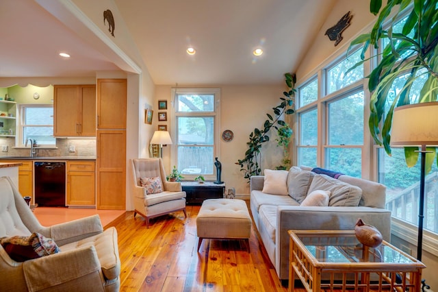living room with plenty of natural light, light wood-type flooring, recessed lighting, and lofted ceiling