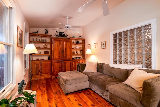 living area with a ceiling fan, lofted ceiling, and hardwood / wood-style floors