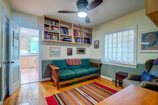 sitting room featuring wood finished floors, baseboards, and ceiling fan