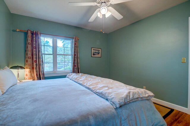 bedroom with wood finished floors, baseboards, and ceiling fan