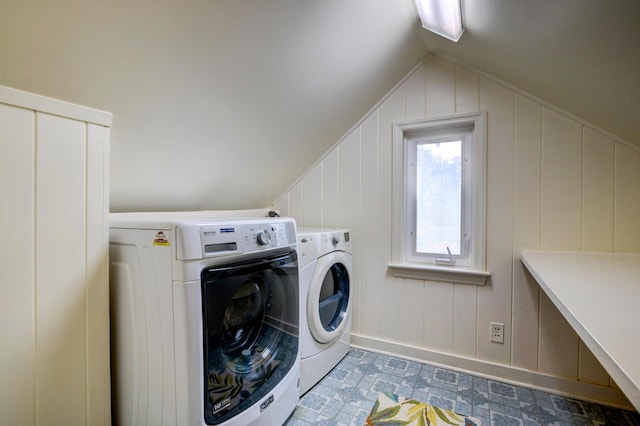washroom with washing machine and clothes dryer, baseboards, and a decorative wall