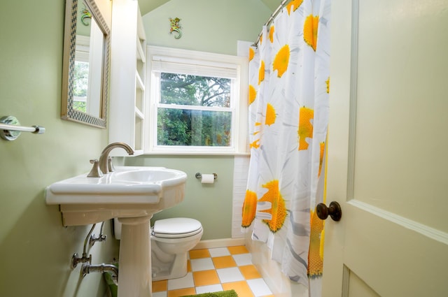 bathroom featuring toilet, tile patterned floors, and shower / tub combo with curtain