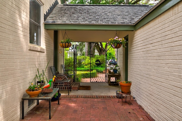 entrance to property with a gate and roof with shingles