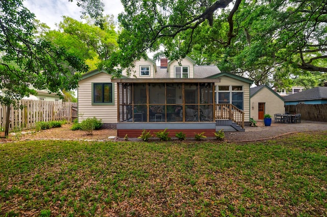 rear view of house featuring a sunroom and a patio