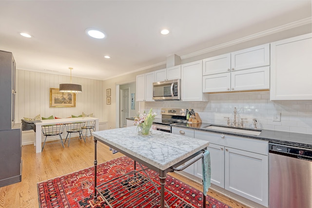 803 Burnett Dr, Charleston, SC 29412 - kitchen with stainless steel appliances, a sink, crown molding, light wood-style floors, and white cabinetry