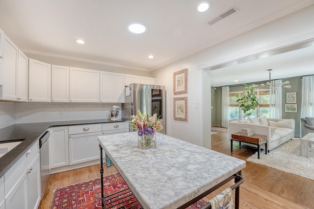 803 Burnett Dr, Charleston, SC 29412 - kitchen with light wood-type flooring, white cabinetry, crown molding, appliances with stainless steel finishes, and open floor plan