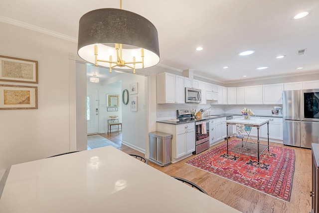 803 Burnett Dr, Charleston, SC 29412 - kitchen featuring stainless steel appliances, ornamental molding, light wood-type flooring, white cabinetry, and a chandelier