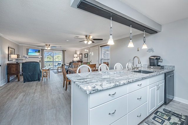 kitchen featuring light wood-type flooring, ceiling fan, decorative light fixtures, sink, and white cabinets