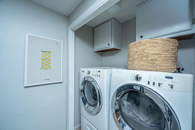 washroom featuring washing machine and clothes dryer and cabinets