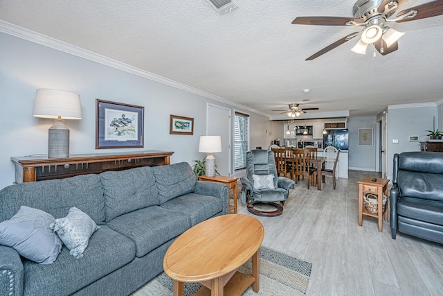 living room with ornamental molding, a textured ceiling, and ceiling fan