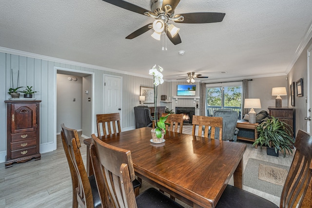 dining room with a textured ceiling, crown molding, and ceiling fan