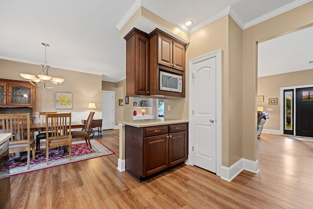 727 Sonny Boy Ln, Johns Island, SC 29455 - kitchen featuring stainless steel microwave, light wood finished floors, a chandelier, light countertops, and baseboards