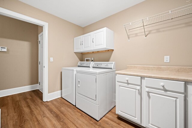 727 Sonny Boy Ln, Johns Island, SC 29455 - laundry area featuring washer and dryer, light wood-type flooring, cabinet space, and baseboards