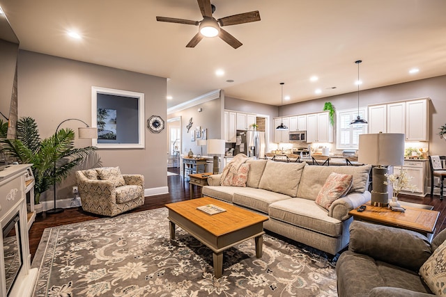 living room with ornamental molding, ceiling fan, and dark hardwood / wood-style flooring