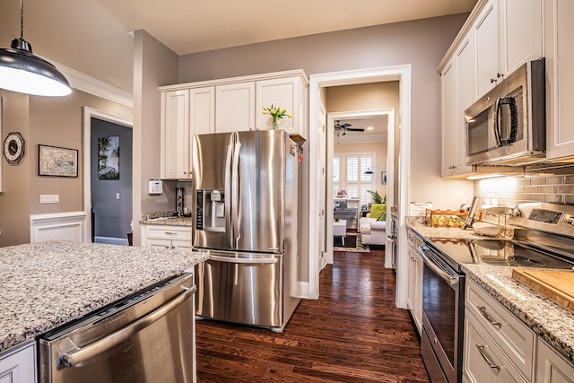 kitchen with dark wood-type flooring, appliances with stainless steel finishes, decorative light fixtures, and white cabinets