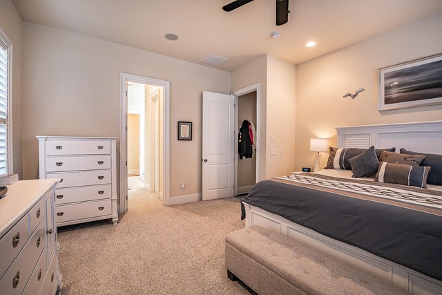 bedroom featuring ceiling fan, light carpet, and multiple windows