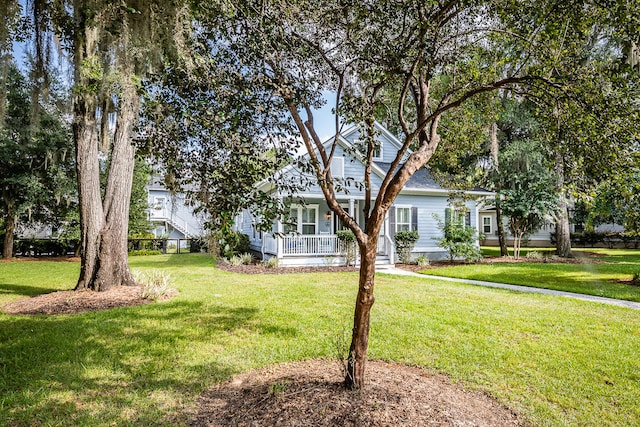 view of front of home with covered porch and a front lawn