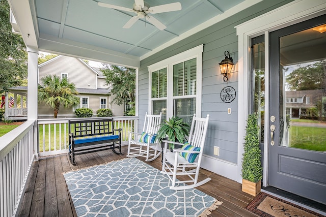 wooden terrace featuring covered porch and ceiling fan