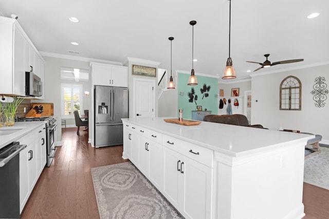 kitchen featuring crown molding, white cabinetry, hanging light fixtures, a center island, and high end appliances