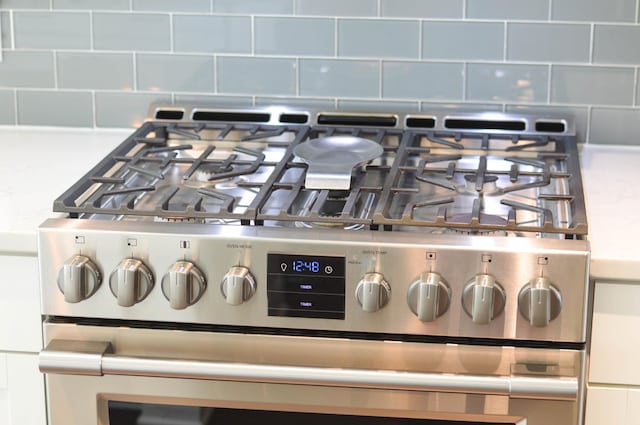 room details featuring tasteful backsplash and gas stove