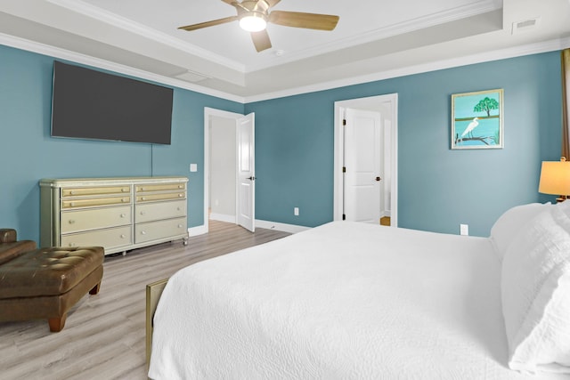 bedroom featuring crown molding, ceiling fan, a raised ceiling, and hardwood / wood-style flooring