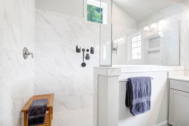 bathroom featuring vanity, lofted ceiling, and tiled shower