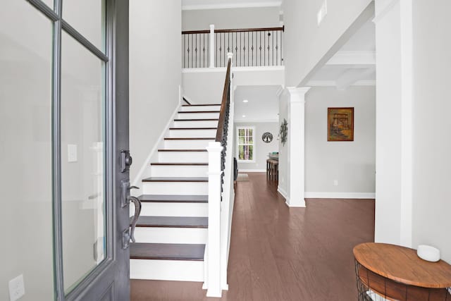 entryway featuring ornate columns, dark wood-type flooring, and beam ceiling