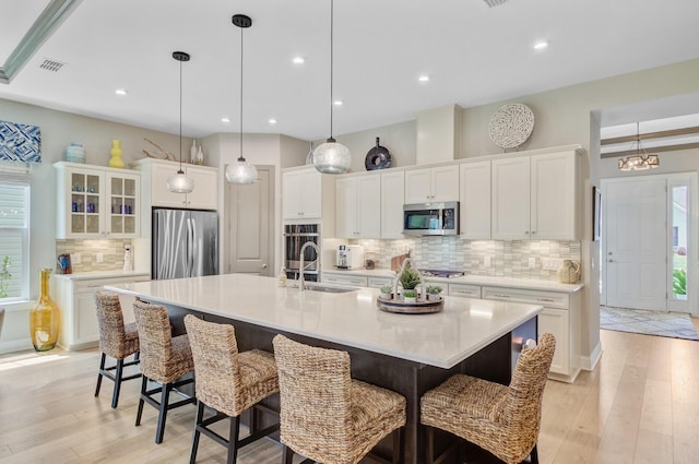 366 Tupelo Lake Dr, Summerville, SC 29486 - kitchen with stainless steel appliances, decorative backsplash, light wood-type flooring, white cabinets, and recessed lighting