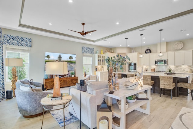 366 Tupelo Lake Dr, Summerville, SC 29486 - living room with light wood finished floors, a tray ceiling, a ceiling fan, and recessed lighting