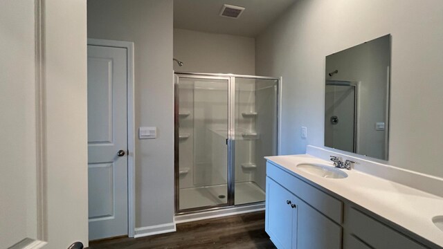 bathroom with an enclosed shower, hardwood / wood-style flooring, and vanity