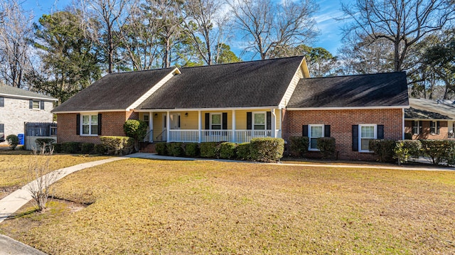 view of front of property with brick siding, a porch, and a front yard