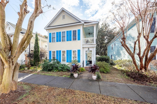 view of front of home with ceiling fan and a balcony