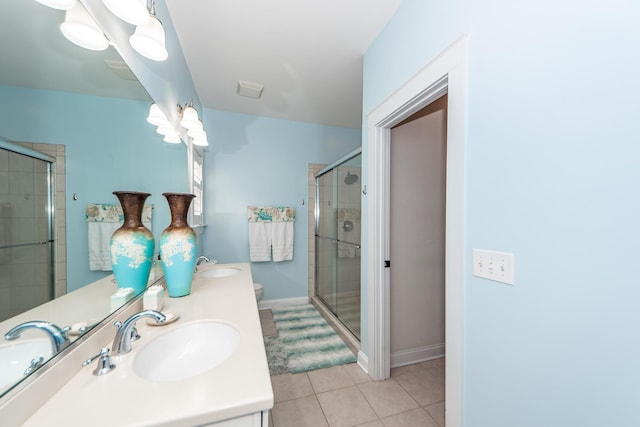 bathroom featuring tile patterned flooring, vanity, toilet, and an enclosed shower