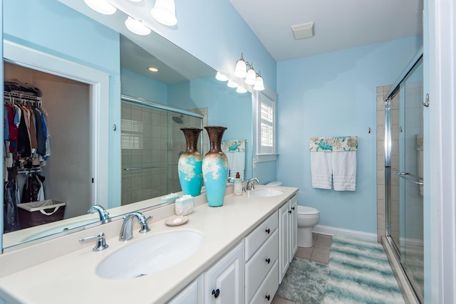 bathroom with tile patterned floors, vanity, toilet, and walk in shower