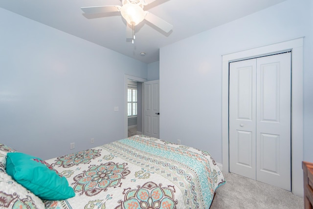 carpeted bedroom featuring ceiling fan and a closet