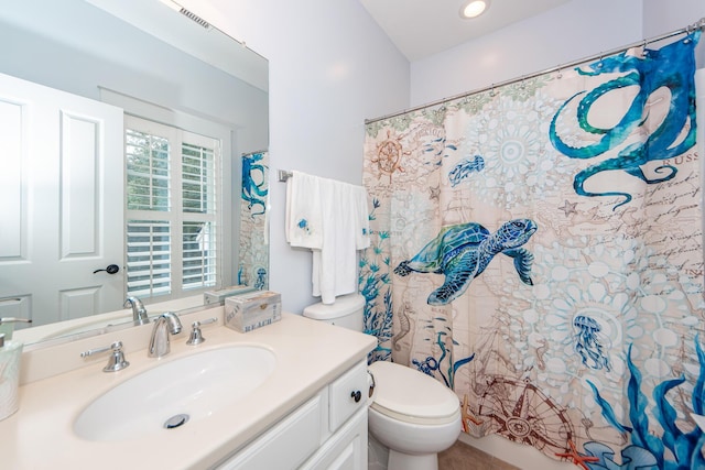 bathroom with curtained shower, vanity, and toilet