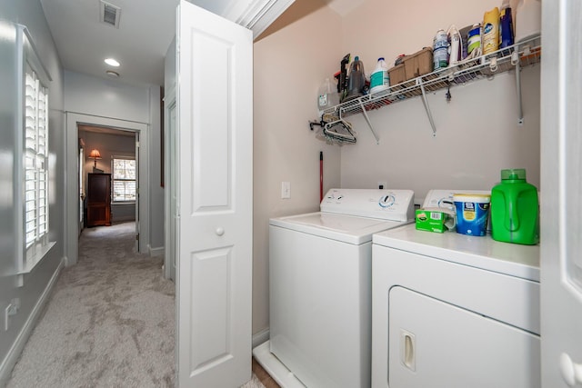 laundry room featuring washing machine and clothes dryer and light carpet