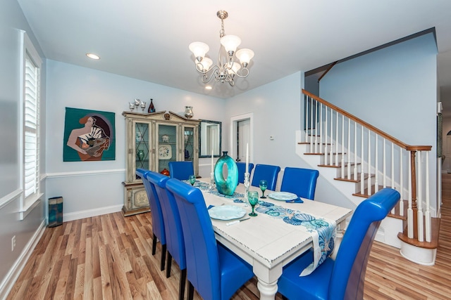 dining room with light hardwood / wood-style flooring and a chandelier