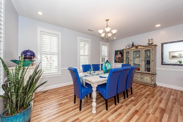 dining space featuring an inviting chandelier and light wood-type flooring